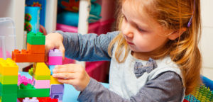 Niña jugando con piezas de madera