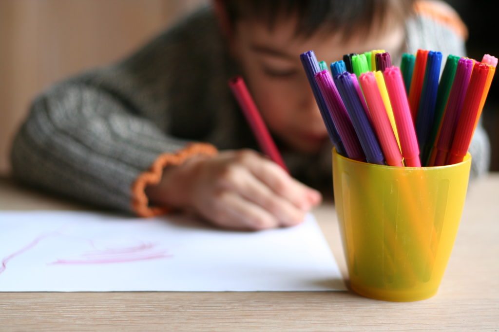Niño dibujando en clase en su vuelta al cole
